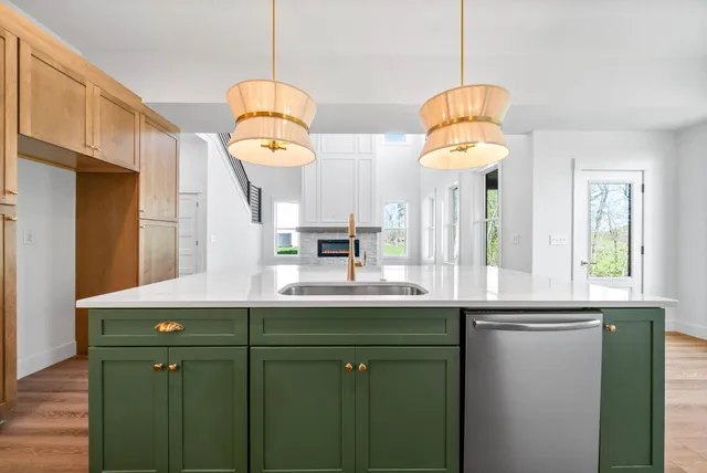 a kitchen with a sink a window and chairs