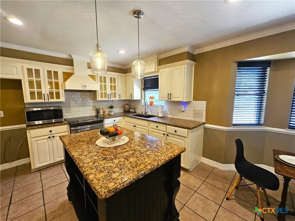 a spacious bedroom with a bed and a chandelier