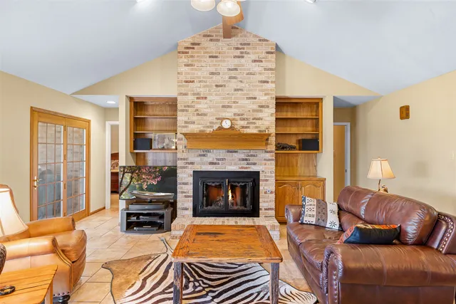 a living room with furniture a fireplace and a chandelier