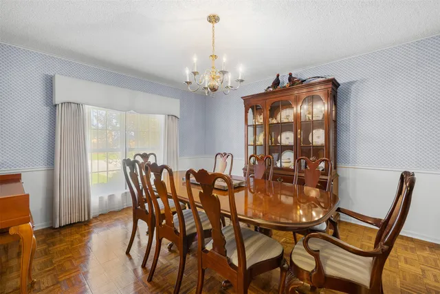 a view of a dining room with furniture and a chandelier