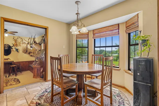 a dining room with furniture a chandelier and window