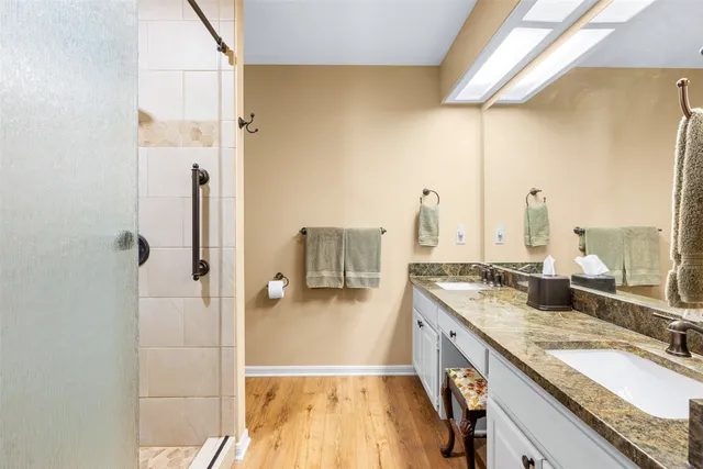 a bathroom with a granite countertop sink and a shower