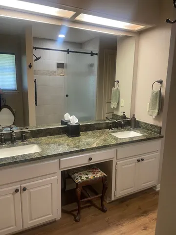 a bathroom with a granite countertop sink and a mirror