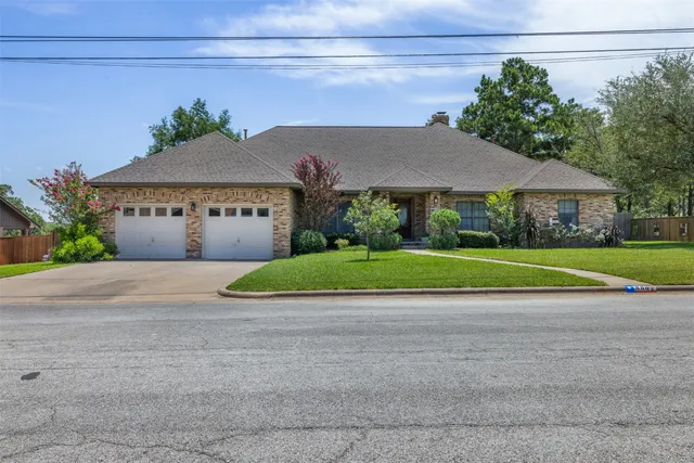 a view of a house with a yard and potted plants