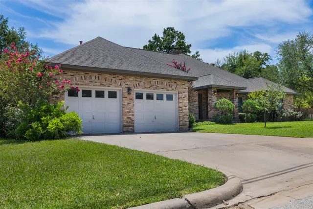 a view of a house with a yard and potted plants