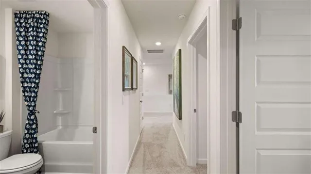 a bathroom with a shower a toilet and a window