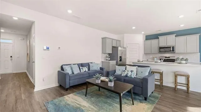 a living room with kitchen island furniture and a kitchen view