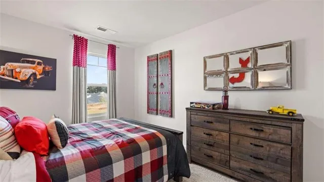 a bedroom with a bed and a dresser in it