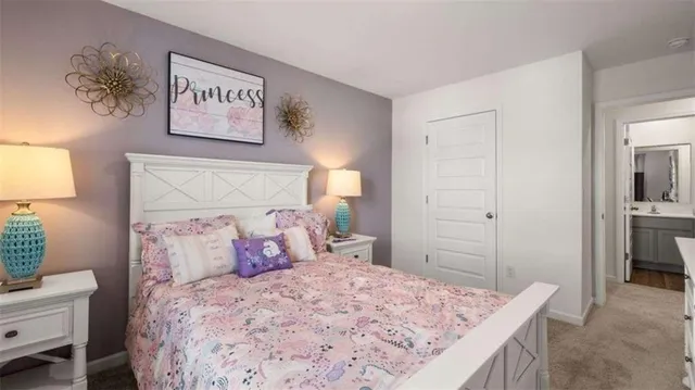 a bedroom with a bed and a lamp on dresser