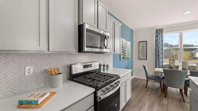 a kitchen with stainless steel appliances granite countertop a stove a sink and a microwave
