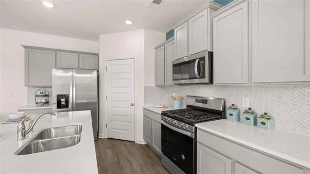 a kitchen with stainless steel appliances granite countertop a sink stove and refrigerator