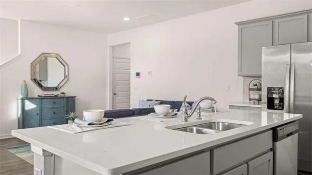 a kitchen with a sink a counter and a refrigerator