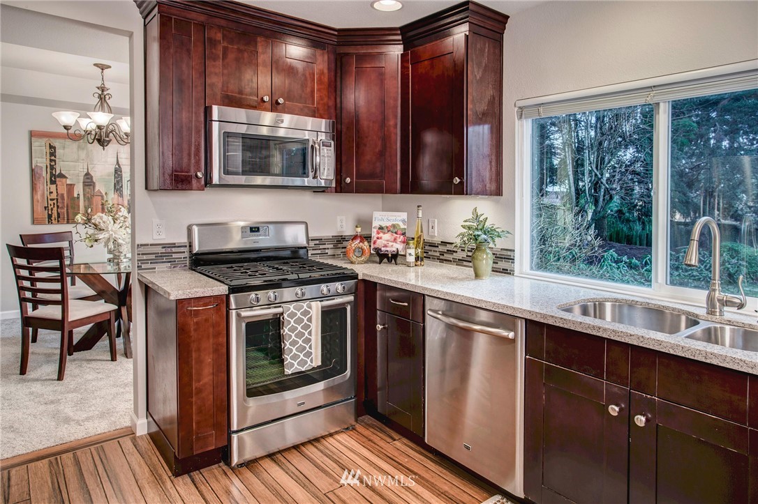 23613 Meridian Place West Bothell, WA 98021 - Photo 11 of 32 a kitchen with stainless steel appliances wooden cabinets and a stove top oven