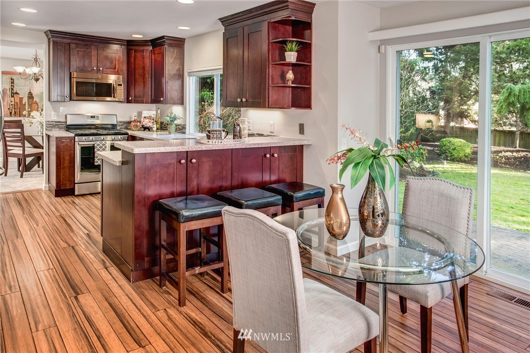 23613 Meridian Place West Bothell, WA 98021 - Photo 15 of 32 a kitchen with stainless steel appliances granite countertop a dining table chairs and granite counter tops