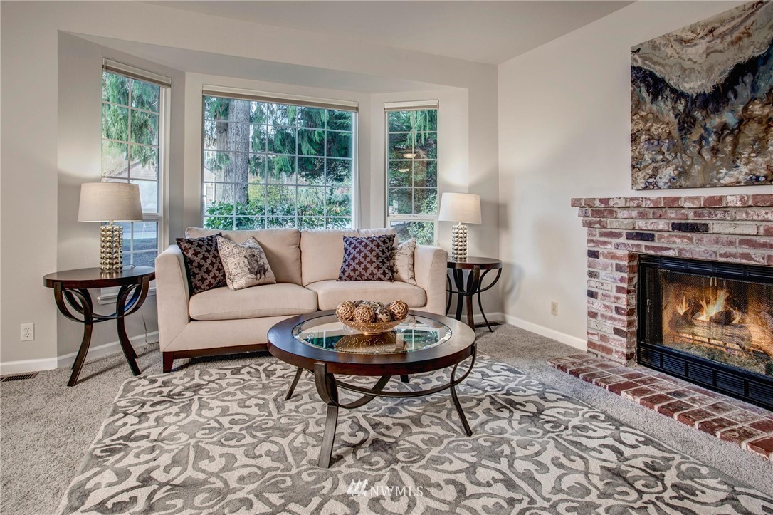 23613 Meridian Place West Bothell, WA 98021 - Photo 6 of 32 a living room with furniture a rug a lamp and a fireplace