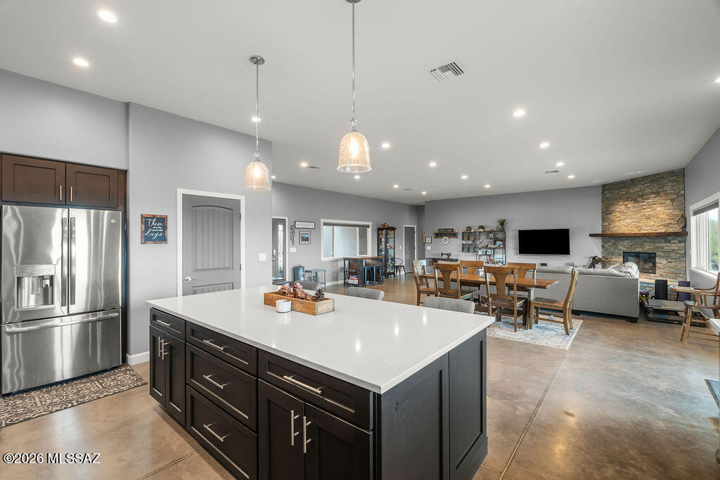 16276 East Empire View Road Vail, AZ 85641 - Photo 18 of 51 a kitchen with a refrigerator a kitchen island a sink and chairs