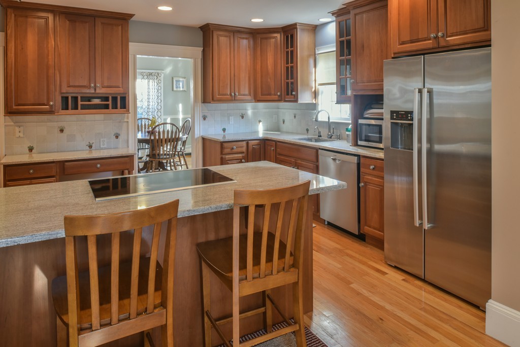 24 Homestead Road Marblehead, MA 01945 - Photo 13 of 29 a kitchen with stainless steel appliances granite countertop a refrigerator a stove a sink a dining table and chairs with wooden floor