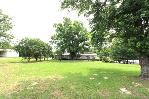 a view of a field with trees in the background