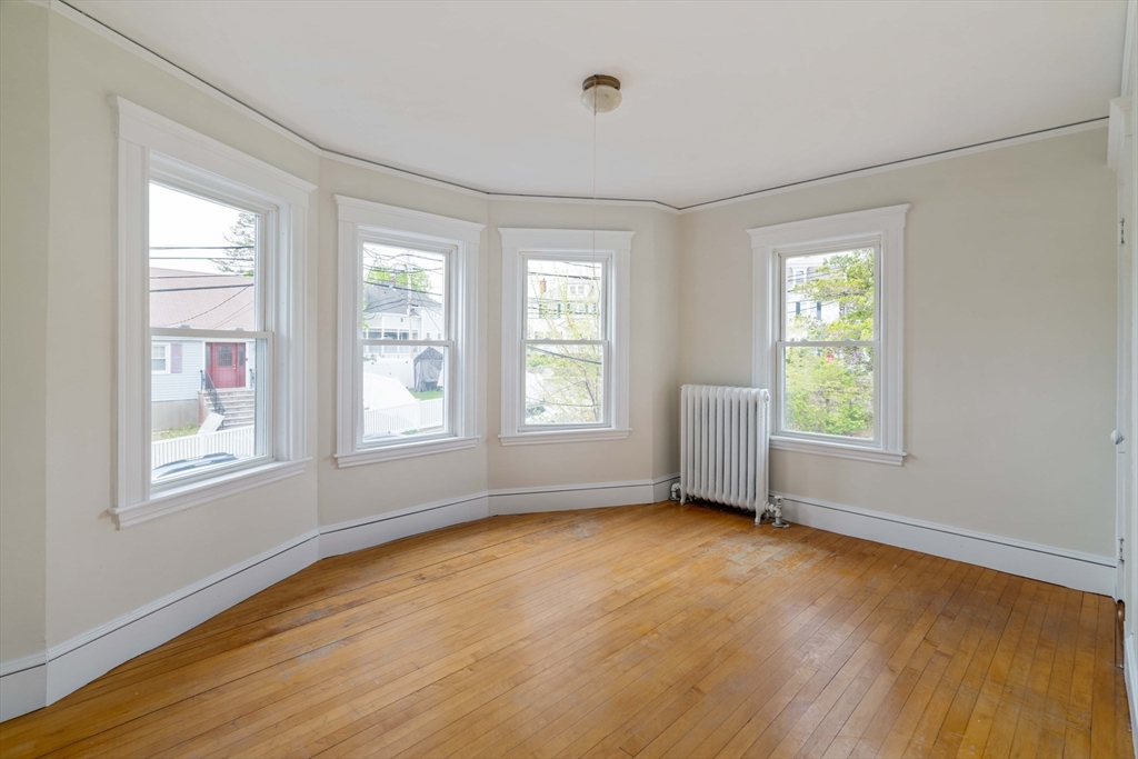 21 Perkins Avenue Boston, MA 02136 - Photo 20 of 26 a view of an empty room with wooden floor and a window