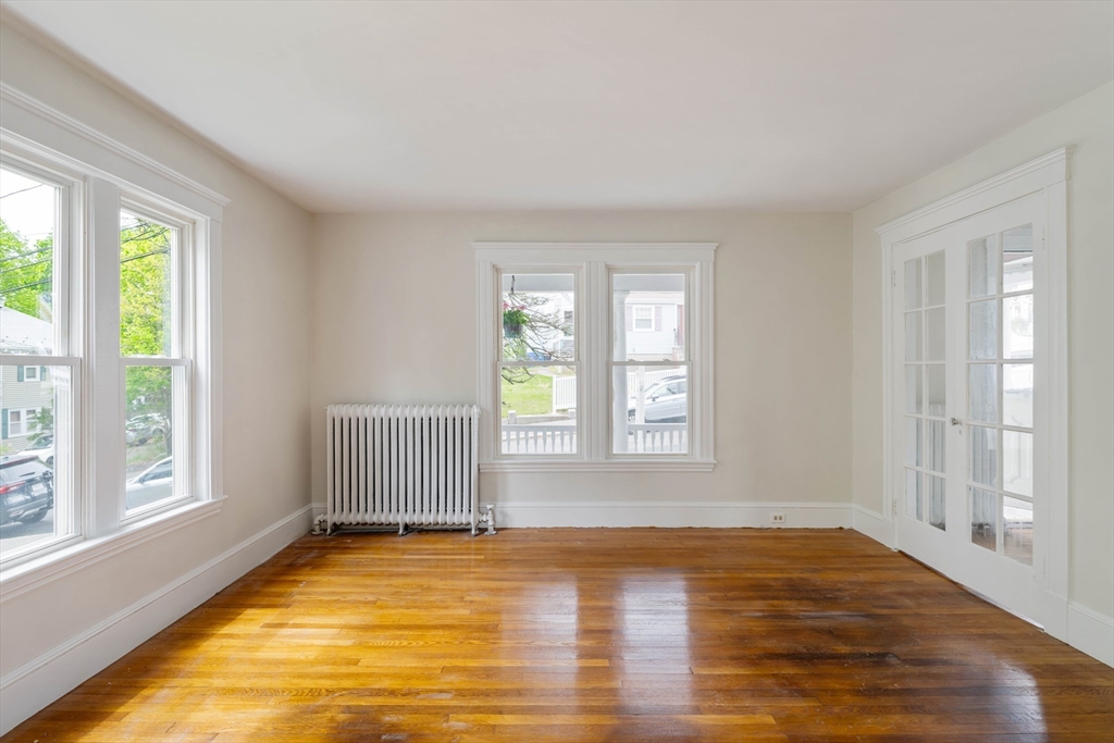 21 Perkins Avenue Boston, MA 02136 - Photo 4 of 26 a view of an empty room with wooden floor and a window