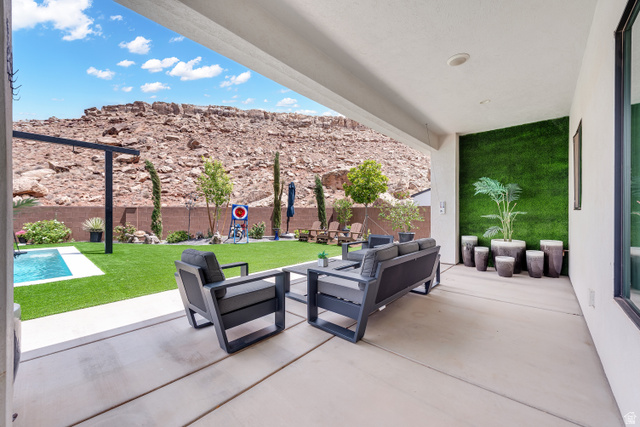 6105 Bunda Way St. George, UT 84790 - Photo 30 of 49 Covered patio featuring an artificial grass wall and concrete flooring