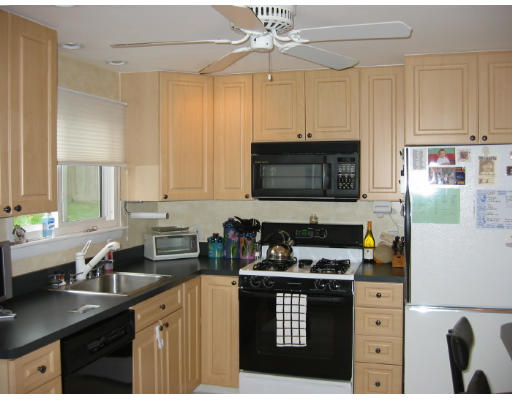 11 Daley Street Needham, MA 02494 - Photo 5 of 6 a kitchen with stainless steel appliances a stove a sink a stove a microwave and cabinets