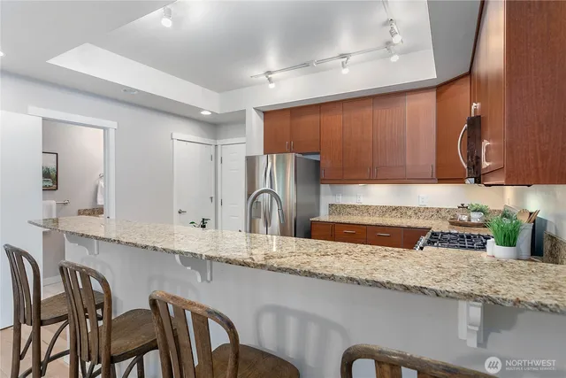 a kitchen with granite countertop a table chairs sink and cabinets