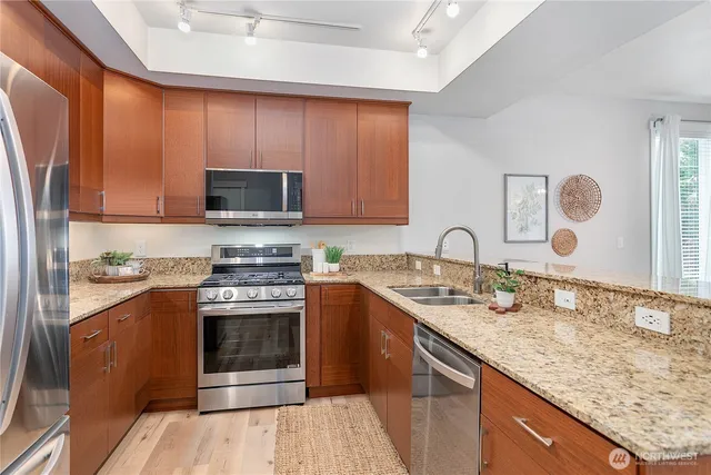 a kitchen with stainless steel appliances granite countertop a stove a sink and a microwave