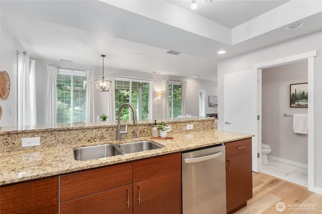 a bathroom with a granite countertop sink and a large mirror