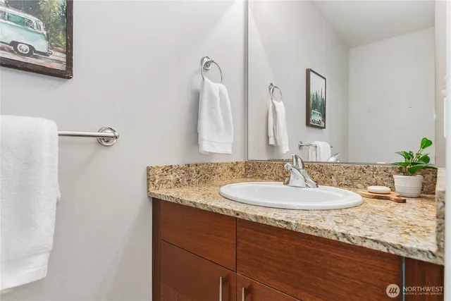 a bathroom with a granite countertop sink and a mirror