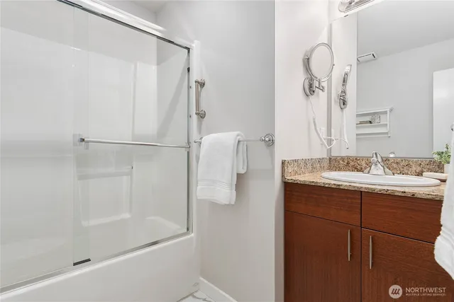 a bathroom with a granite countertop sink mirror and a bathtub