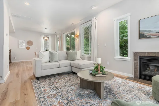 a living room with furniture a large window and a fireplace