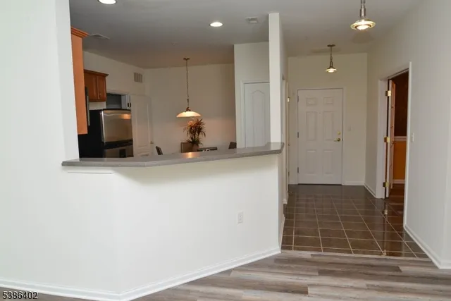 a view of a hallway with wooden floor and a cabinet