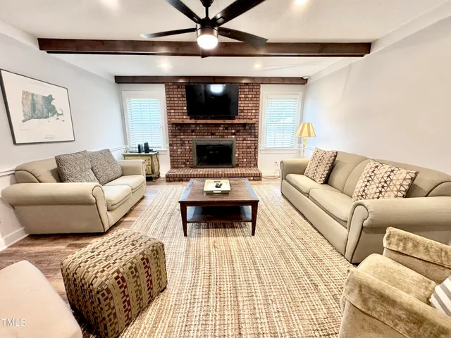 a living room with furniture a rug and a ceiling fan