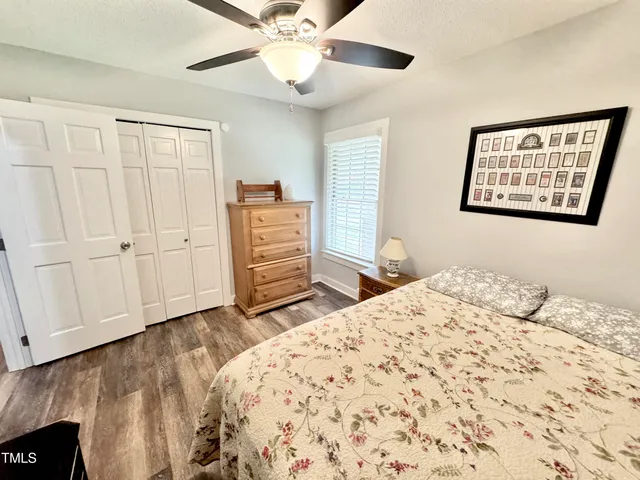 a bedroom with a bed wooden floor and window