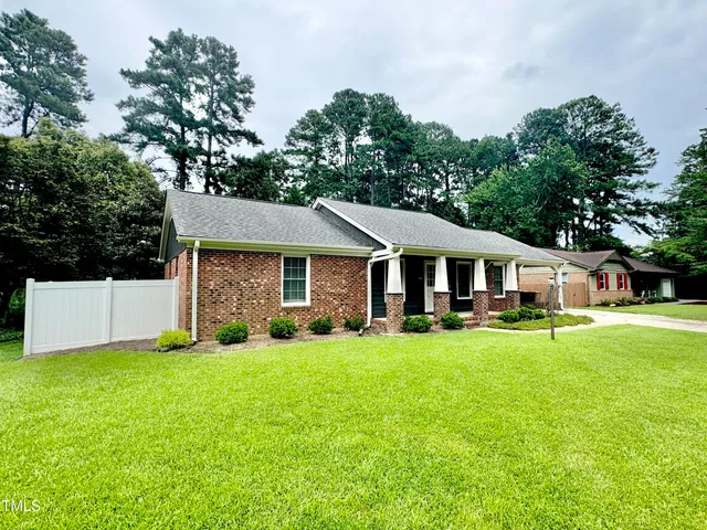 a view of a house with a yard and sitting area