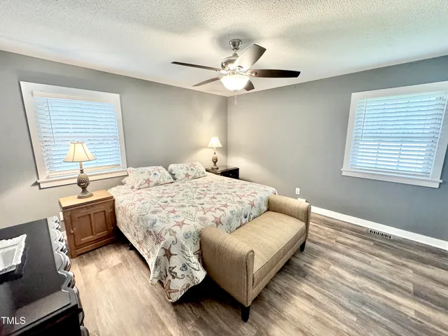 a bedroom with a bed furniture and wooden floor