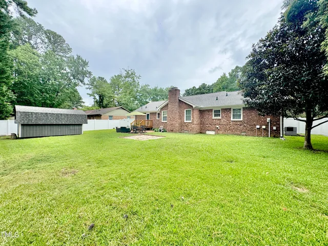 a view of a patio with couches table and chairs under an umbrella