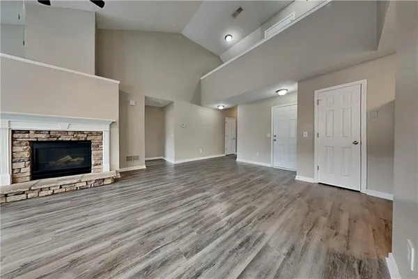 an empty room with wooden floor and fireplace