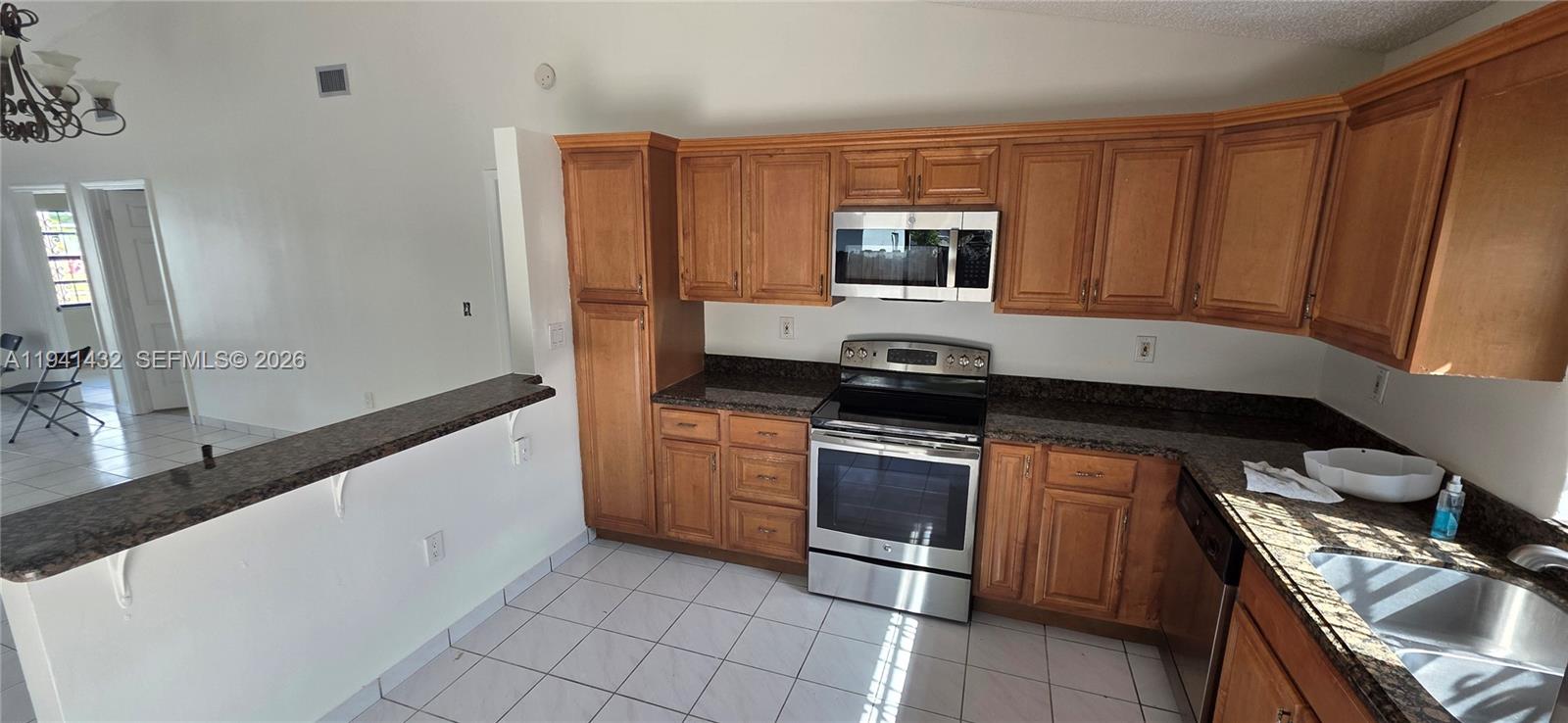 15238 Southwest 58th Terrace Miami, FL 33193 - Photo 22 of 46 a kitchen with stainless steel appliances granite countertop a stove microwave and sink