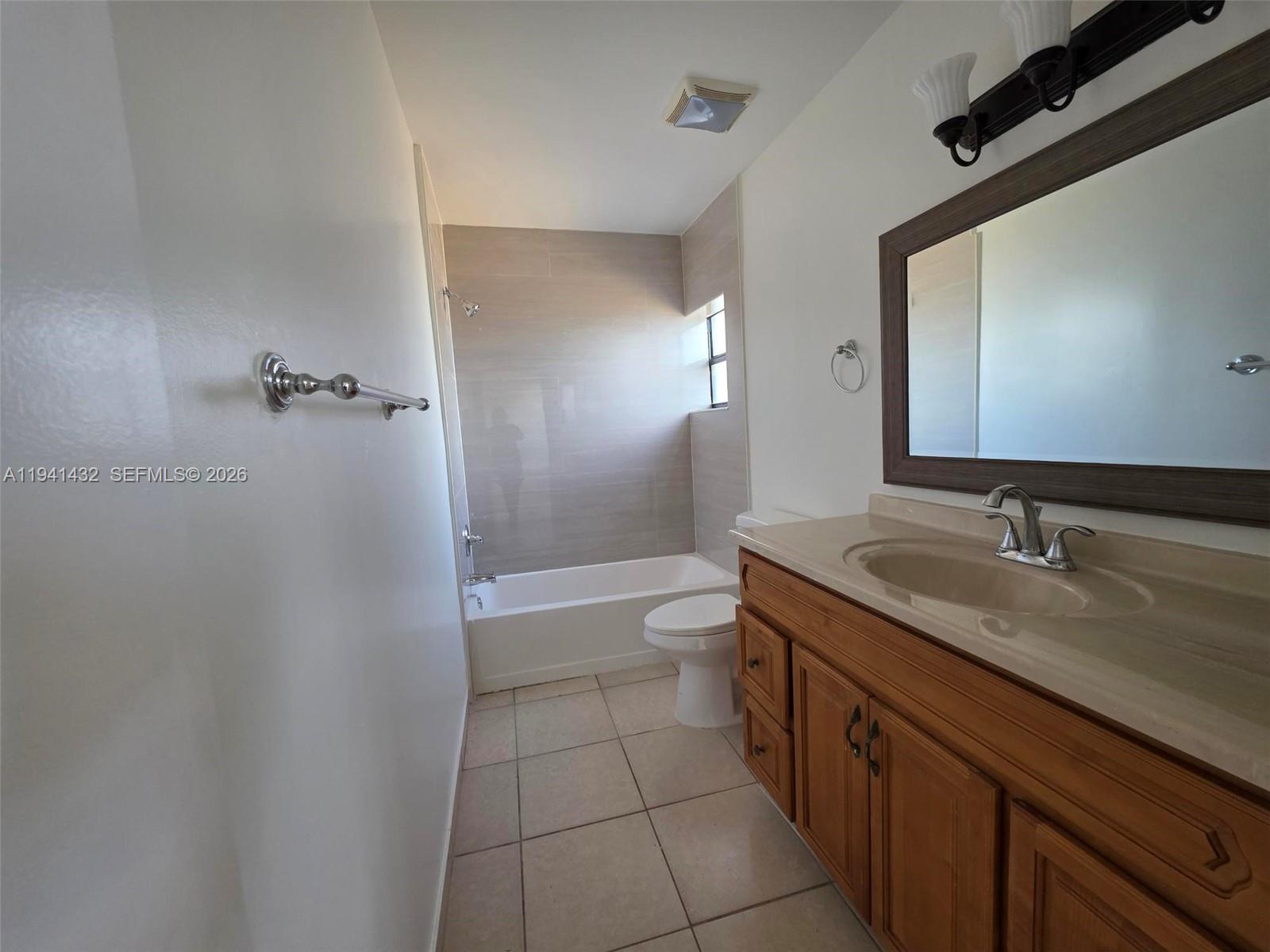 15238 Southwest 58th Terrace Miami, FL 33193 - Photo 22 of 38 a bathroom with a granite countertop sink toilet mirror and bathtub