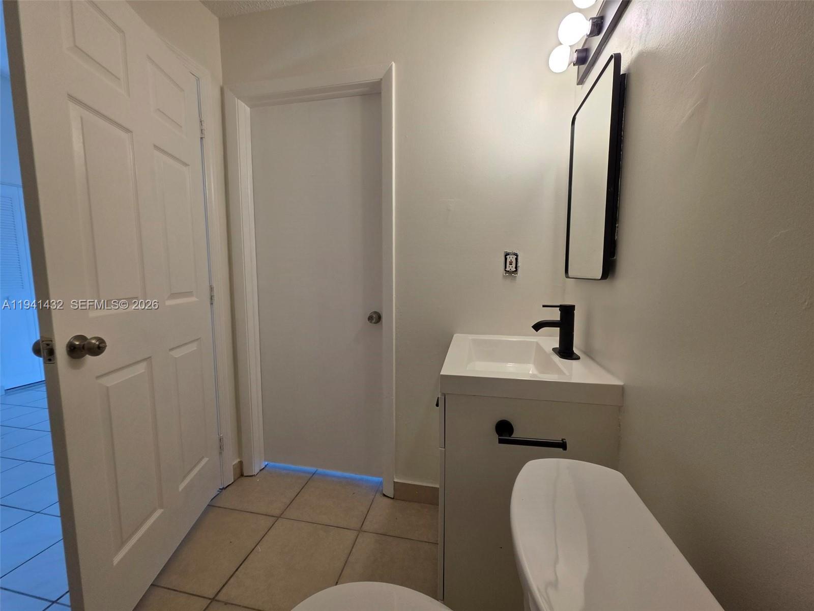 15238 Southwest 58th Terrace Miami, FL 33193 - Photo 23 of 38 a bathroom with a toilet a sink and mirror
