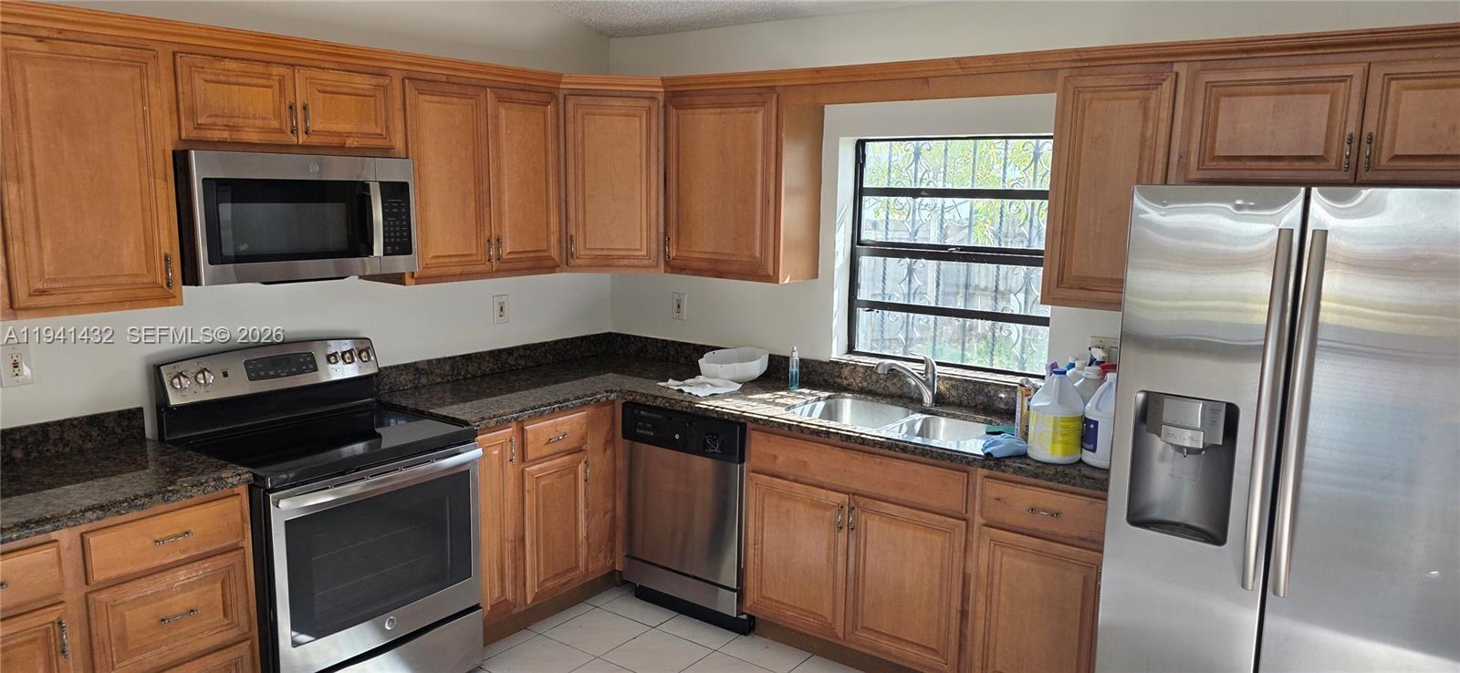 15238 Southwest 58th Terrace Miami, FL 33193 - Photo 25 of 46 a kitchen with stainless steel appliances granite countertop a stove a microwave and a refrigerator