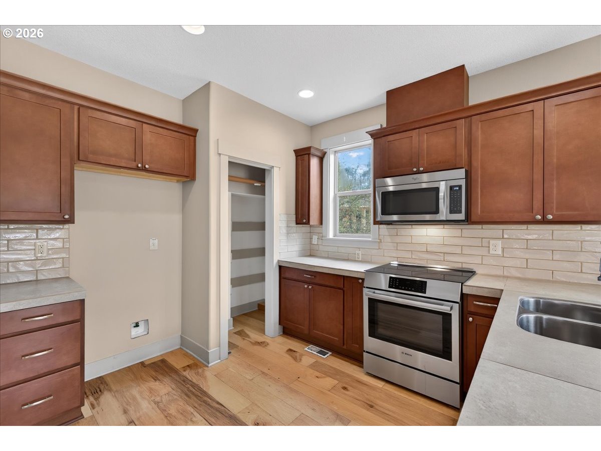 561 North Declaration Drive Carlton, OR 97111 - Photo 9 of 44 a kitchen with stainless steel appliances granite countertop a stove microwave and refrigerator
