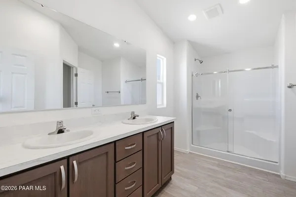 a bathroom with a double vanity sink mirror and shower