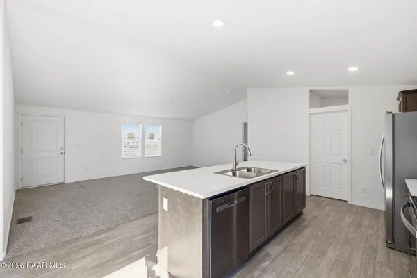 a kitchen with a sink refrigerator and cabinets