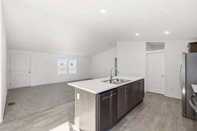 a kitchen with a sink refrigerator and cabinets
