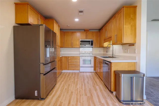 a kitchen with stainless steel appliances a refrigerator and a stove top oven