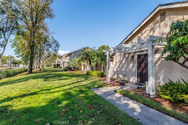 a view of a house with backyard and trees