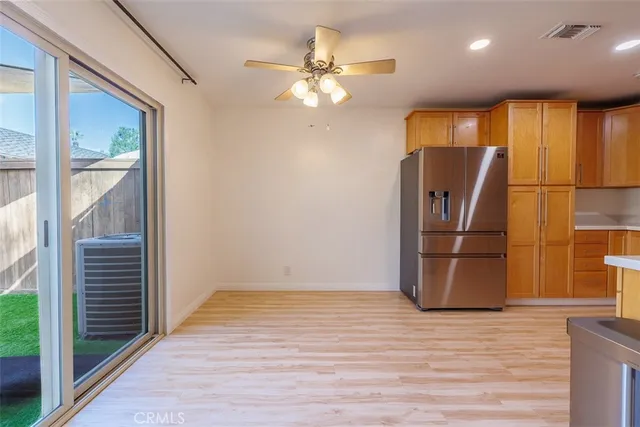 a view of a livingroom with wooden floor and a ceiling fan